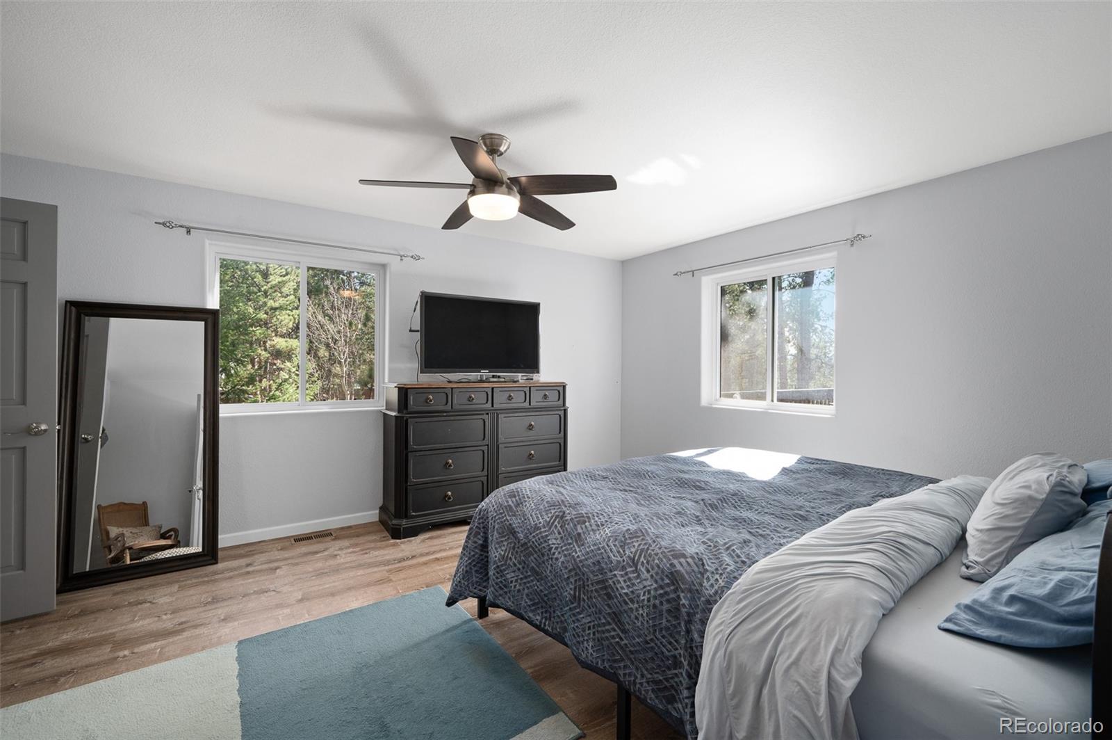 560 Gunsmoke Drive Bailey, CO 80421 - Photo 15 of 43 a bedroom with a bed and a flat screen tv