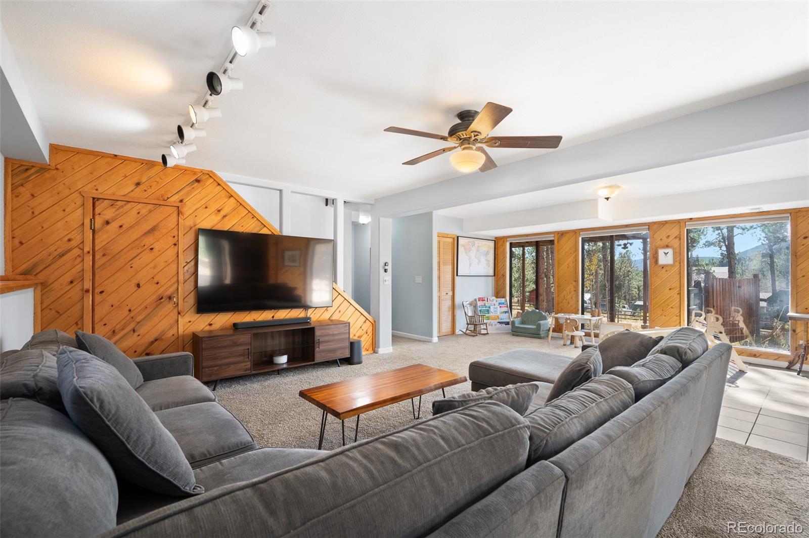 560 Gunsmoke Drive Bailey, CO 80421 - Photo 22 of 43 a living room with furniture a ceiling fan and a flat screen tv