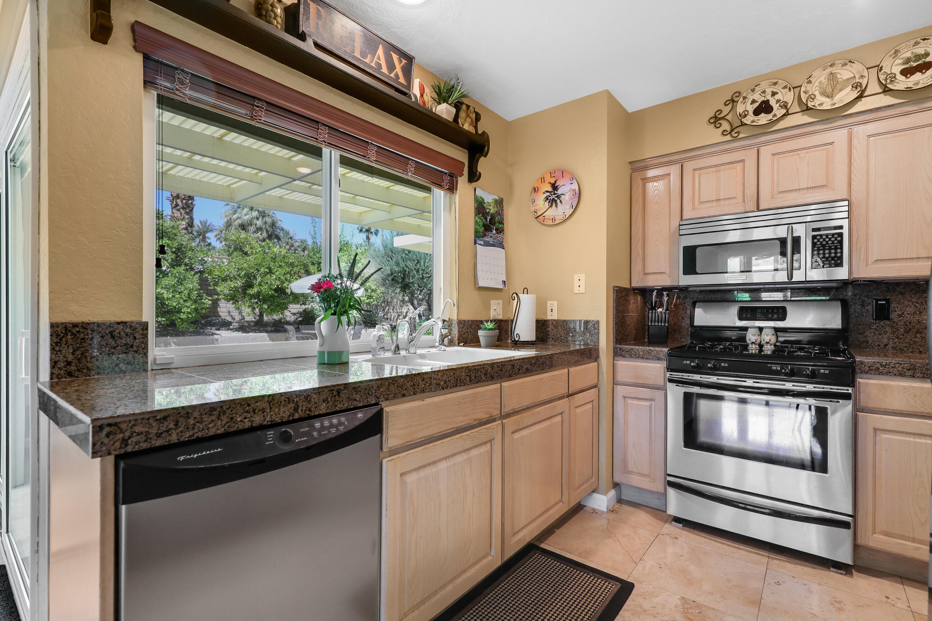 71601 Halgar Road Rancho Mirage, CA 92270 - Photo 12 of 35 a kitchen with stainless steel appliances granite countertop a stove a sink and a microwave