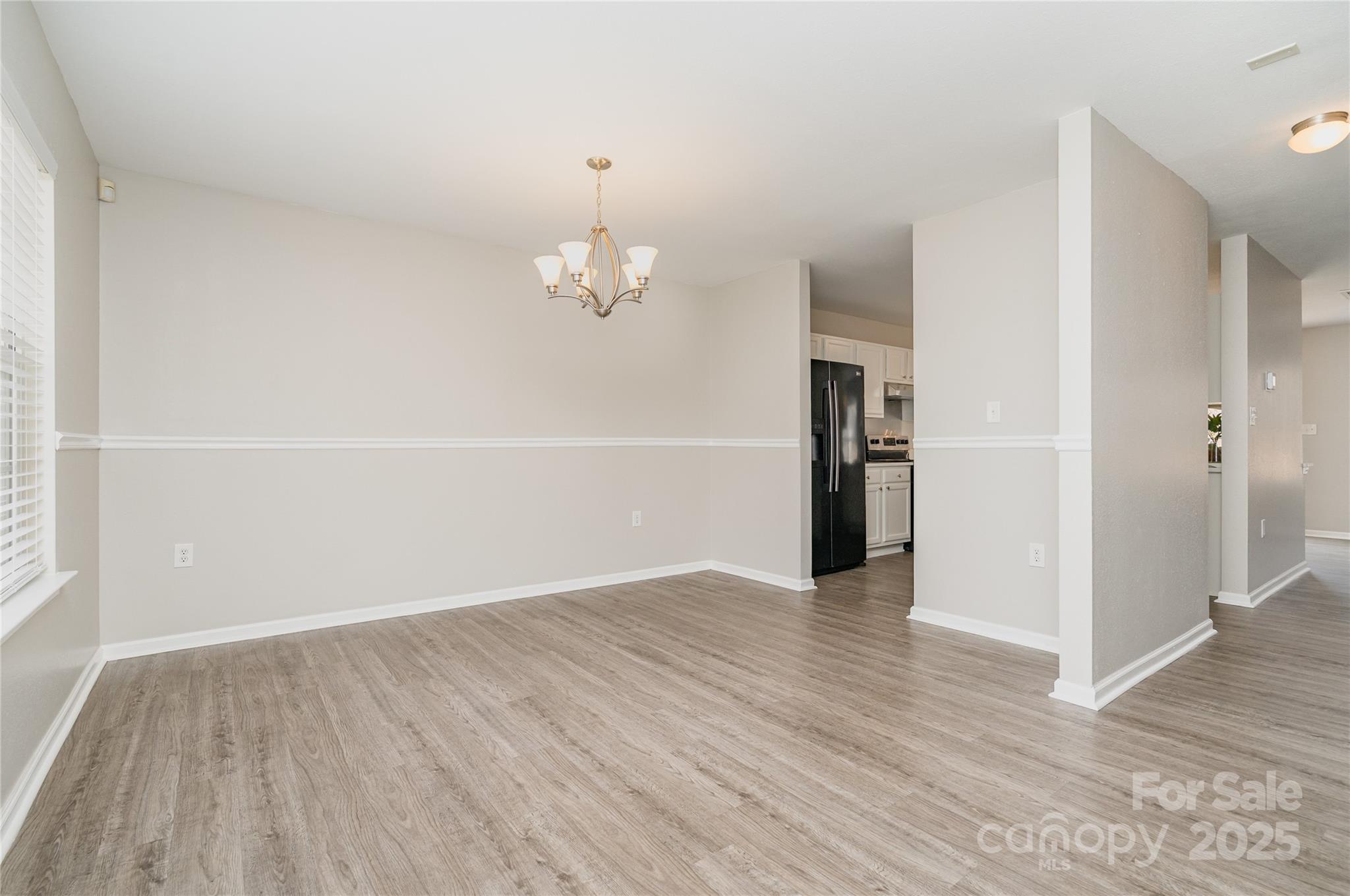 2919 Heather Ridge Road Dallas, NC 28034 - Photo 2 of 24 an empty room with wooden floor and chandelier