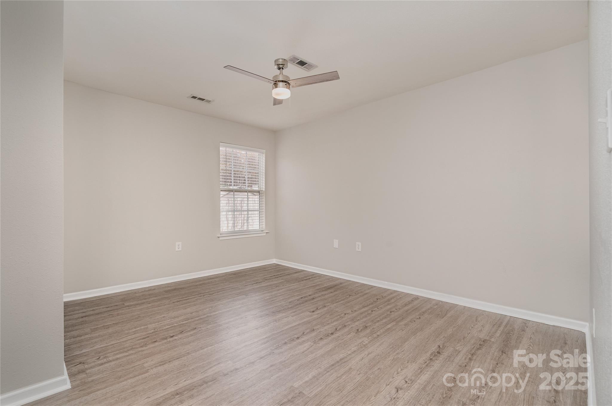 2919 Heather Ridge Road Dallas, NC 28034 - Photo 8 of 24 a view of an empty room with wooden floor and a window