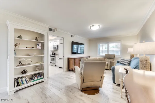 a living room with furniture a window and a flat screen tv