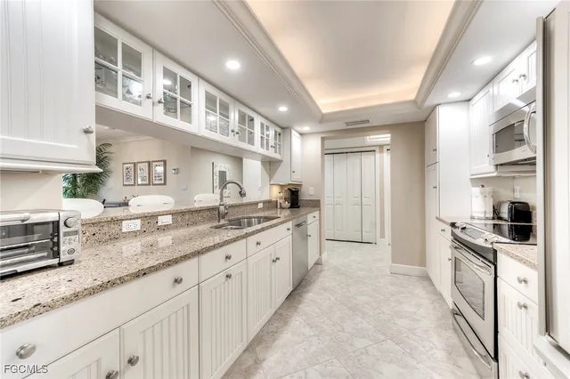 a large kitchen with stainless steel appliances granite countertop a lot of counter space and wooden floors
