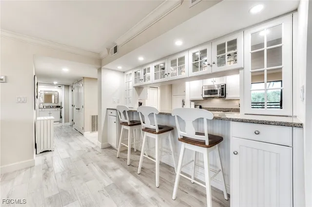 a kitchen with stainless steel appliances kitchen island granite countertop a table chairs and a cabinets