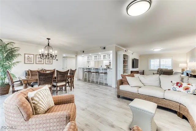 a living room with furniture a chandelier and a large window