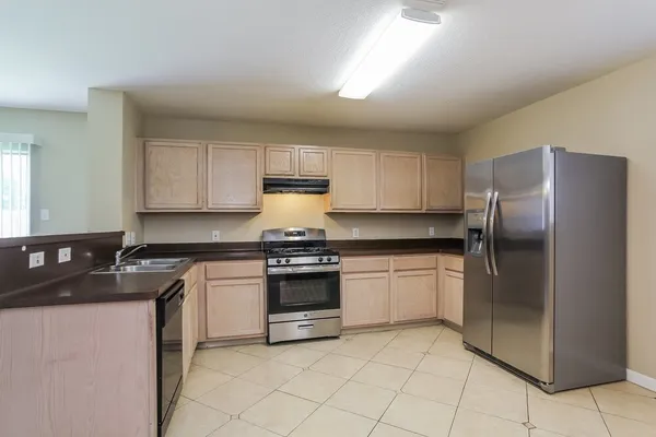 a kitchen with granite countertop white cabinets and stainless steel appliances