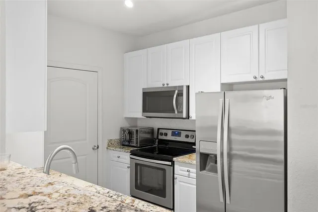 a kitchen with stainless steel appliances granite countertop a refrigerator stove and sink