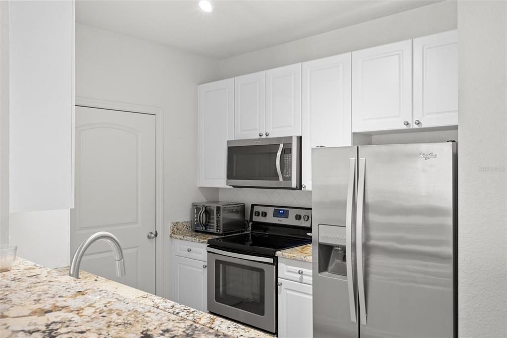 4221 West Spruce Street, Unit 1326 Tampa, FL 33607 - Photo 15 of 45 a kitchen with stainless steel appliances granite countertop a refrigerator stove and sink