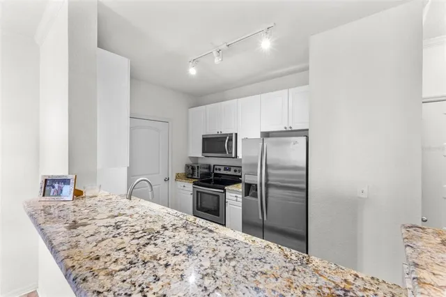 a kitchen with kitchen island a refrigerator sink stove and granite counter top