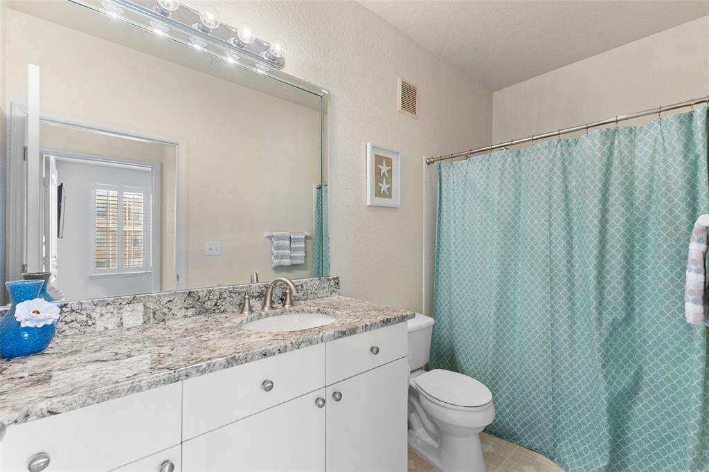 4221 West Spruce Street, Unit 1326 Tampa, FL 33607 - Photo 31 of 45 a bathroom with a granite countertop sink toilet and a mirror