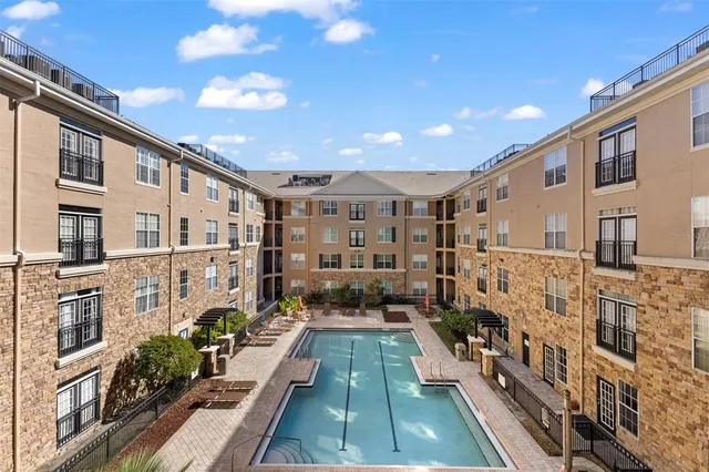 a view of a patio with couches chairs potted plants and wooden floor