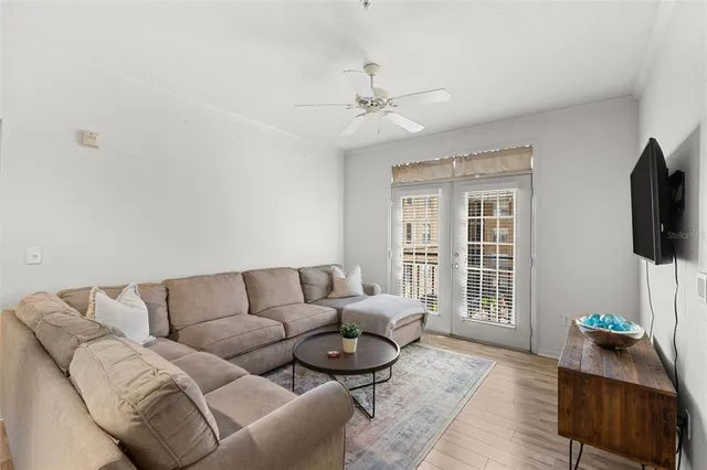 a living room with furniture a flat screen tv and a window