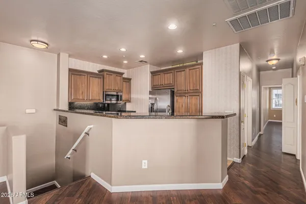 a kitchen with granite countertop a refrigerator and a sink