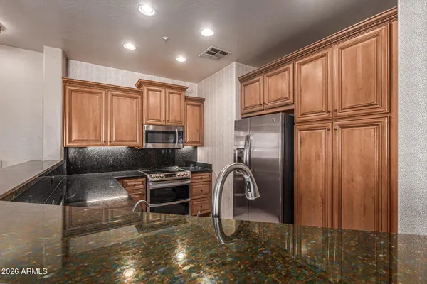 a kitchen with stainless steel appliances granite countertop a sink stove and cabinets