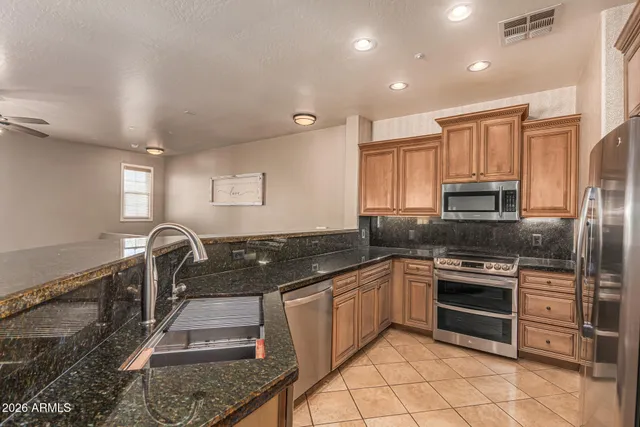 a kitchen with stainless steel appliances granite countertop a stove a refrigerator and a sink
