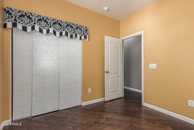 a view of a room that has wooden floor and cabinets