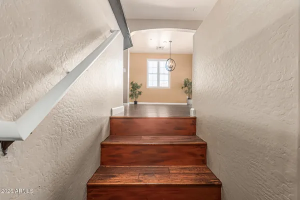 a view of a big room with wooden floor and windows