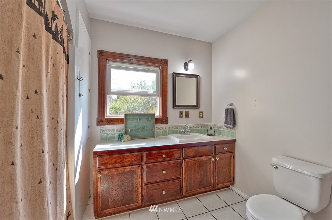 3668 Bay Road Ferndale, WA 98248 - Photo 16 of 40 a bathroom with a granite countertop toilet sink and mirror