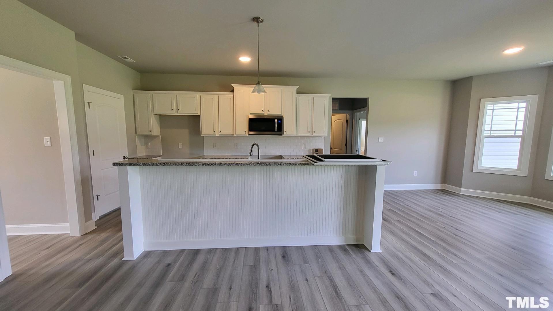 33 Crystal Spgs Way Benson, NC 27504 - Photo 4 of 15 a kitchen with kitchen island granite countertop a sink cabinets and wooden floor