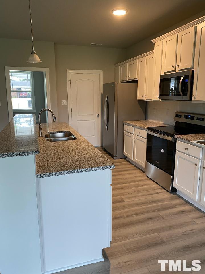 33 Crystal Spgs Way Benson, NC 27504 - Photo 5 of 15 a kitchen with granite countertop a stove top oven a sink dishwasher and a refrigerator with wooden floor