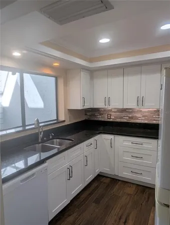 a kitchen with granite countertop a sink and cabinets