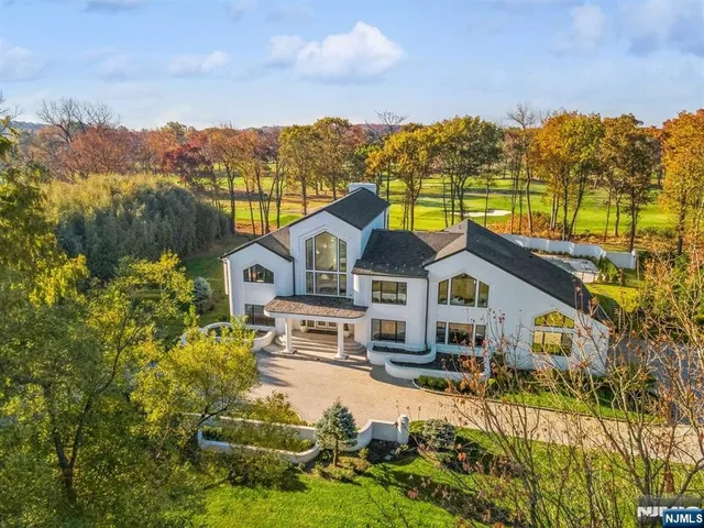a view of a white house with a big yard and large tree