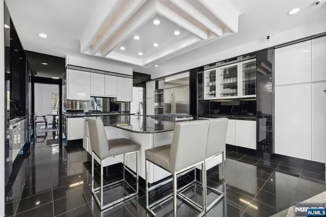 a kitchen with kitchen island a refrigerator and a dining table
