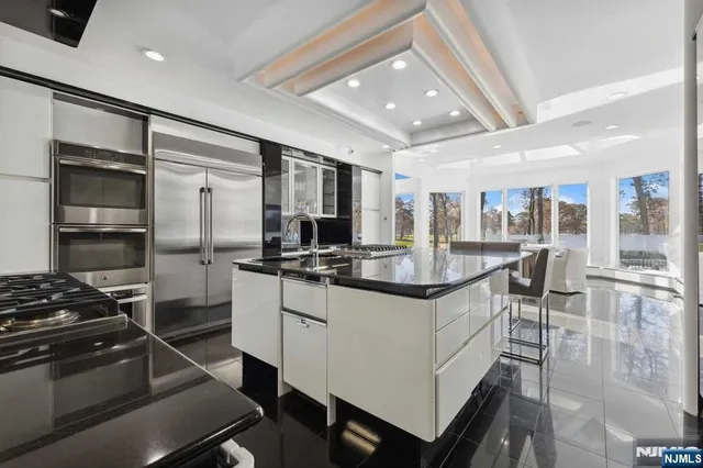 a kitchen with stainless steel appliances kitchen island granite countertop a stove and a refrigerator