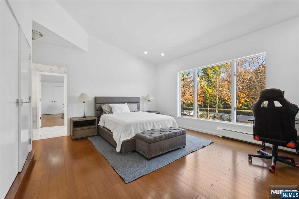 23 Rio Vista Drive Alpine, NJ 07620 - Photo 35 of 47 a spacious bedroom with a bed and wooden floor