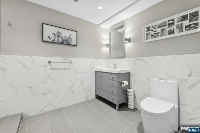 a bathroom with a toilet a sink and a mirror