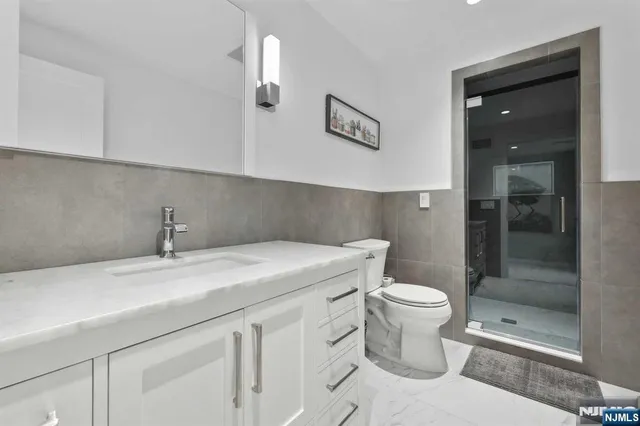 a bathroom with a sink a toilet and shower