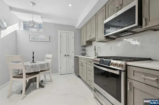 a kitchen with stainless steel appliances granite countertop a stove top oven microwave and cabinets