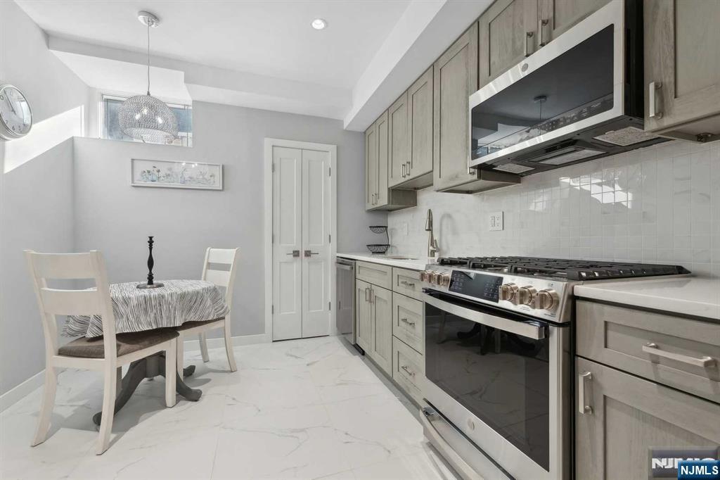 23 Rio Vista Drive Alpine, NJ 07620 - Photo 42 of 47 a kitchen with stainless steel appliances granite countertop a stove top oven microwave and cabinets