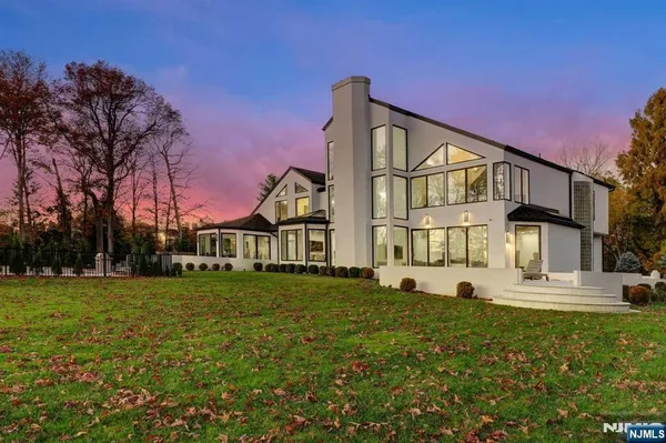 a view of a big house with a big yard and large trees