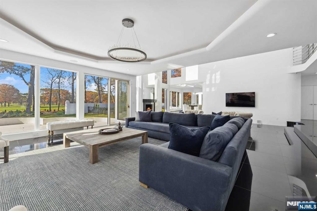 23 Rio Vista Drive Alpine, NJ 07620 - Photo 10 of 47 a living room with furniture a flat screen tv and a large window