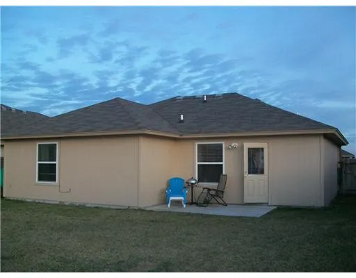 a backyard of a house with table and chairs
