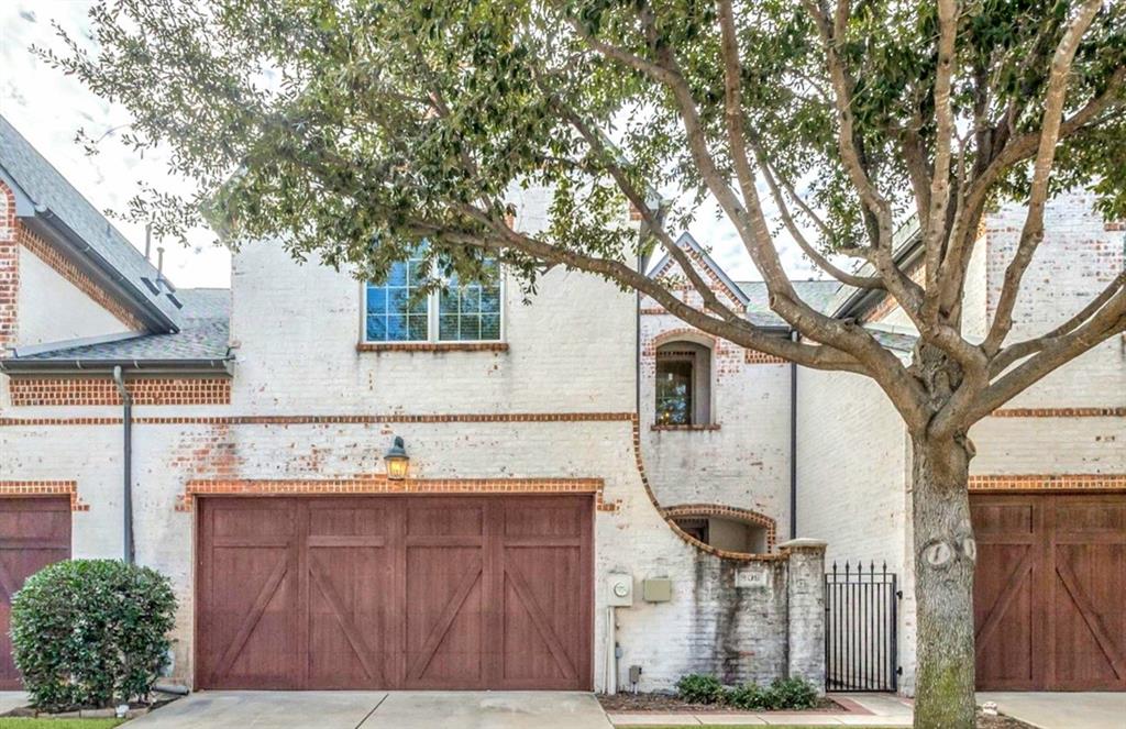 a view of a house with large tree and wooden fence