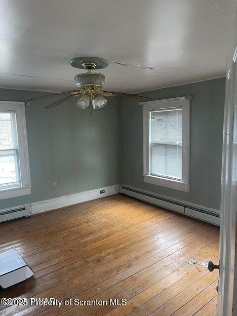23 Village Road Beach Lake, PA 18405 - Photo 15 of 22 an empty room with wooden floor chandelier fan and windows