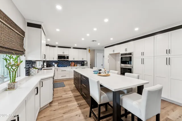 a kitchen with white cabinets and stainless steel appliances
