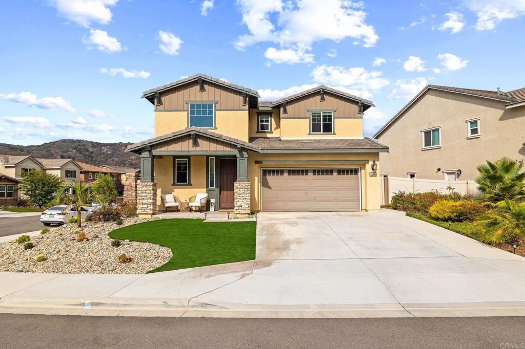 a front view of a house with a garden and mountain view