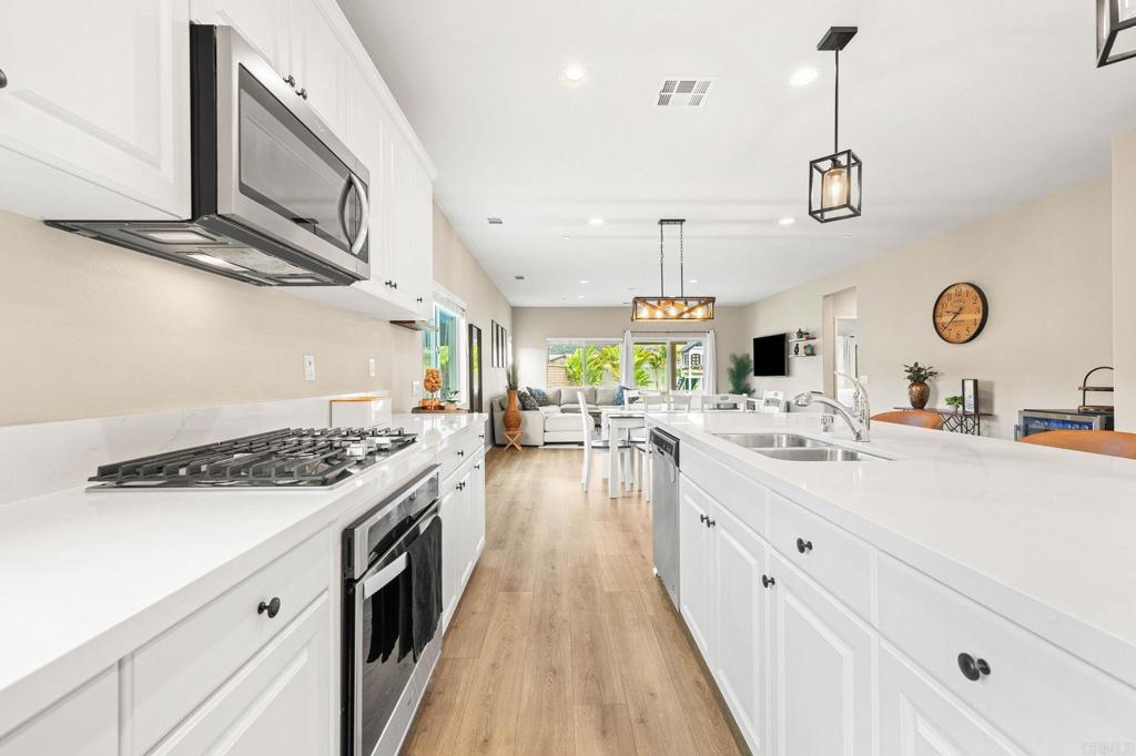 35846 Esperia Way Fallbrook, CA 92028 - Photo 15 of 60 a kitchen with a stove and a clock on the wall