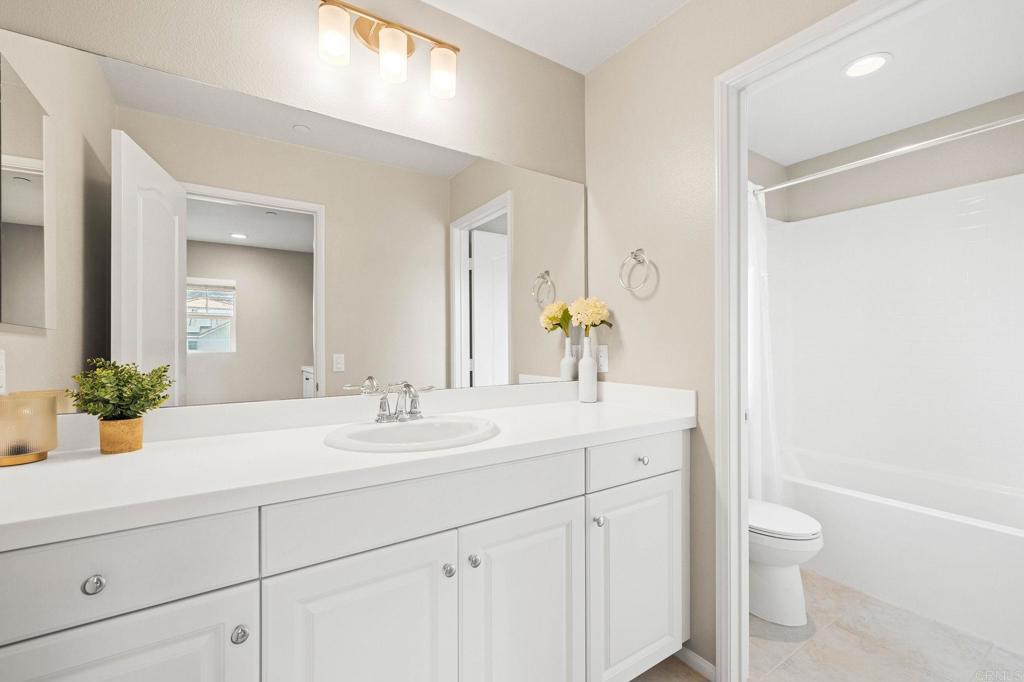 35846 Esperia Way Fallbrook, CA 92028 - Photo 46 of 60 a bathroom with a sink a toilet and a large mirror