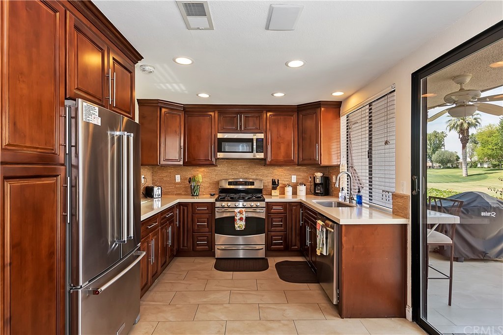 109 Torremolinos Drive Rancho Mirage, CA 92270 - Photo 12 of 33 a kitchen with stainless steel appliances granite countertop refrigerator a stove top oven a sink and dishwasher