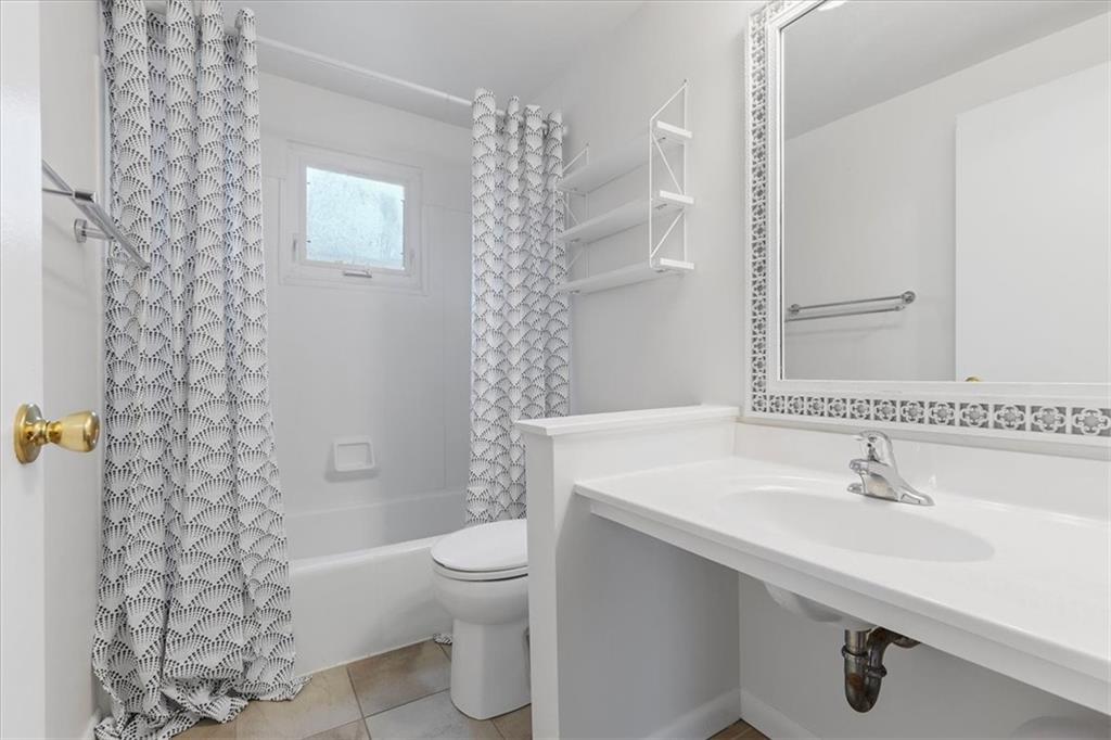78 Seavey Road Pittsburgh, PA 15223 - Photo 21 of 29 Full bath with tub/shower combo, single sink with vanity space, and window letting in natural light.