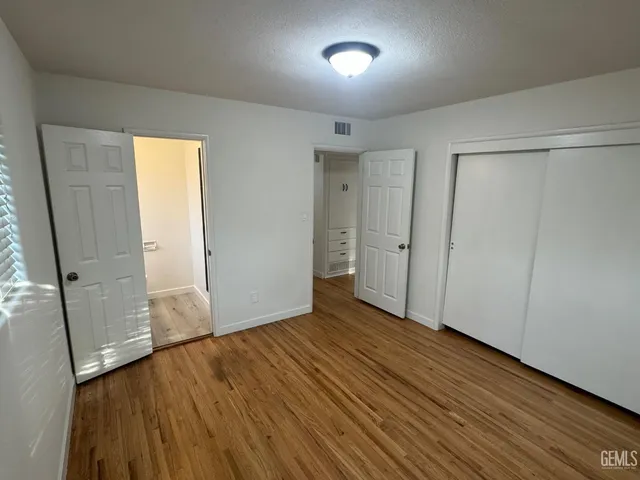 an empty room with wooden floor and sliding door
