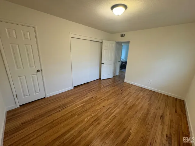 a view of an empty room with wooden floor