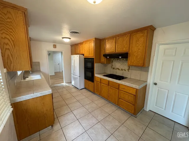 a large kitchen with a sink and a refrigerator