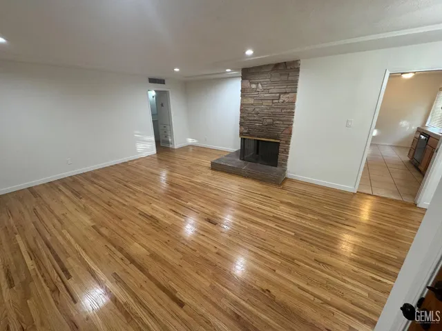 a view of empty room with wooden floor