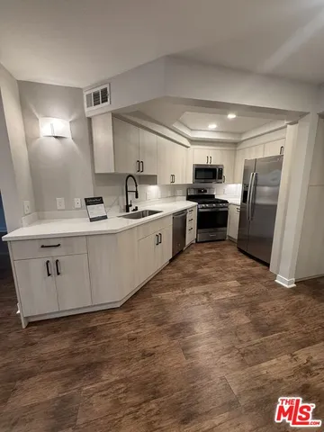 a large kitchen with stainless steel appliances granite countertop a stove a sink dishwasher and a refrigerator