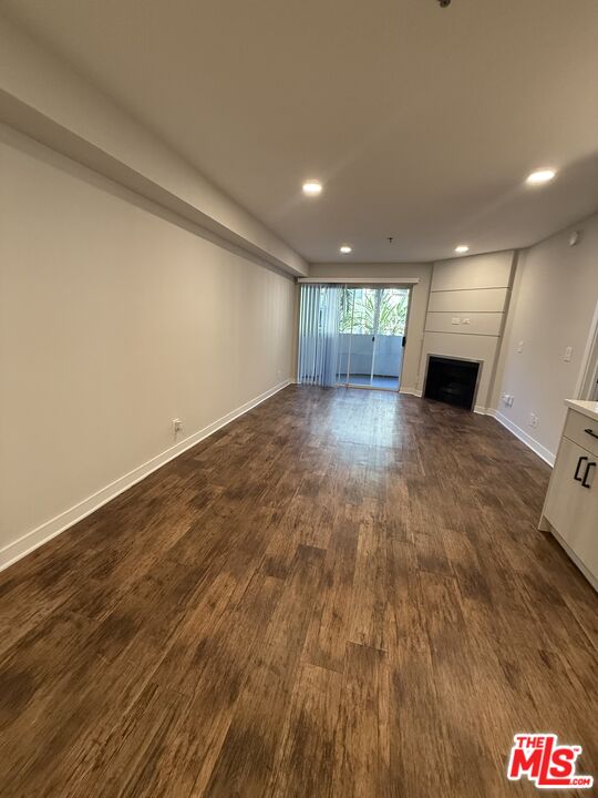 7660 Beverly Boulevard, Unit 237 Los Angeles, CA 90036 - Photo 2 of 7 wooden floor in an empty room with a fireplace